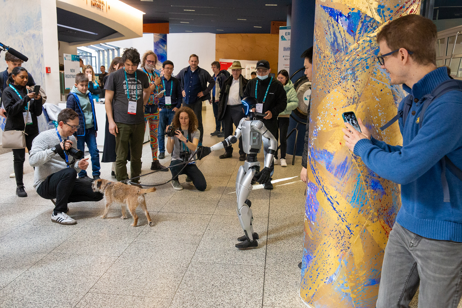 Interessierte schauen beim European Robotics Forum dabei zu, wie ein Roboter einen Hund an der Leine hält